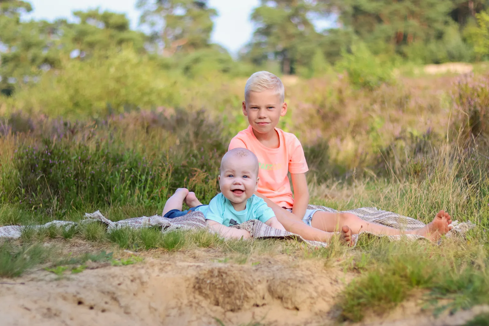 Twee broertjes op een kleedje tussen de heide