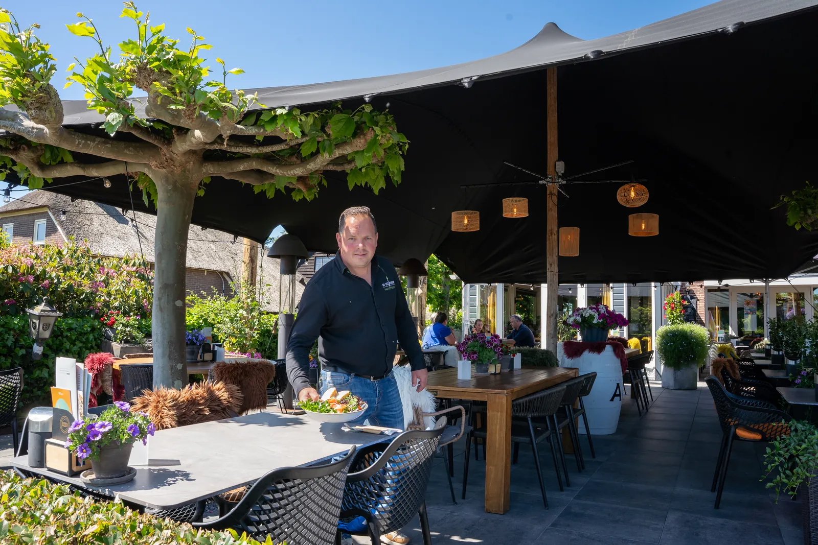 Bedrijfsfotografie: horecaondernemer serveert op zijn terras